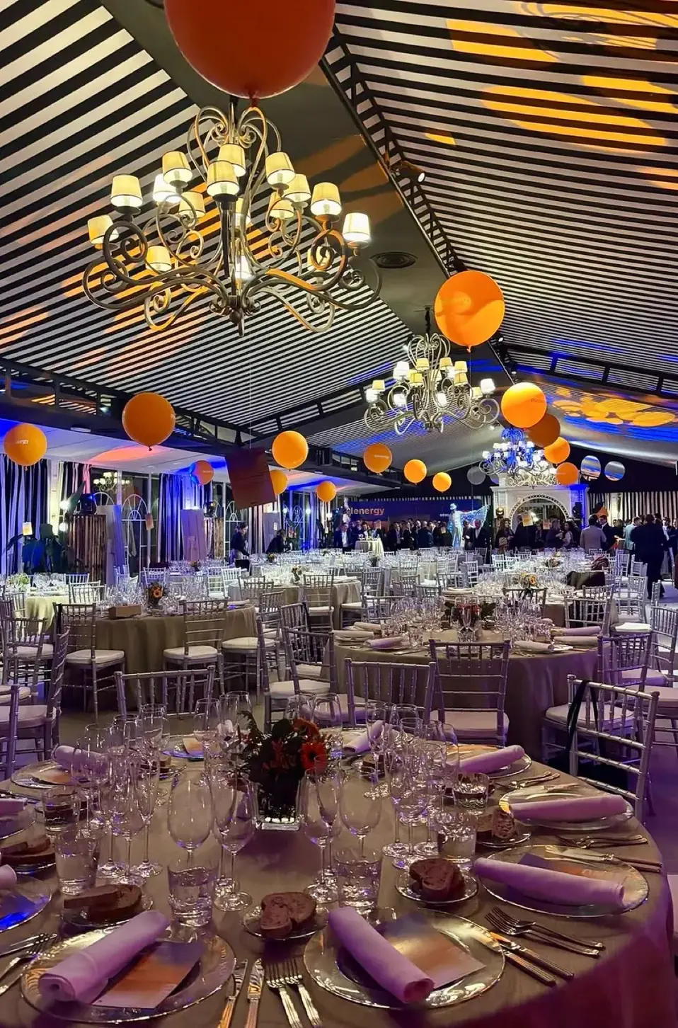 Pabellón decorado para convención · candelabros, mesas redondas y globos energy