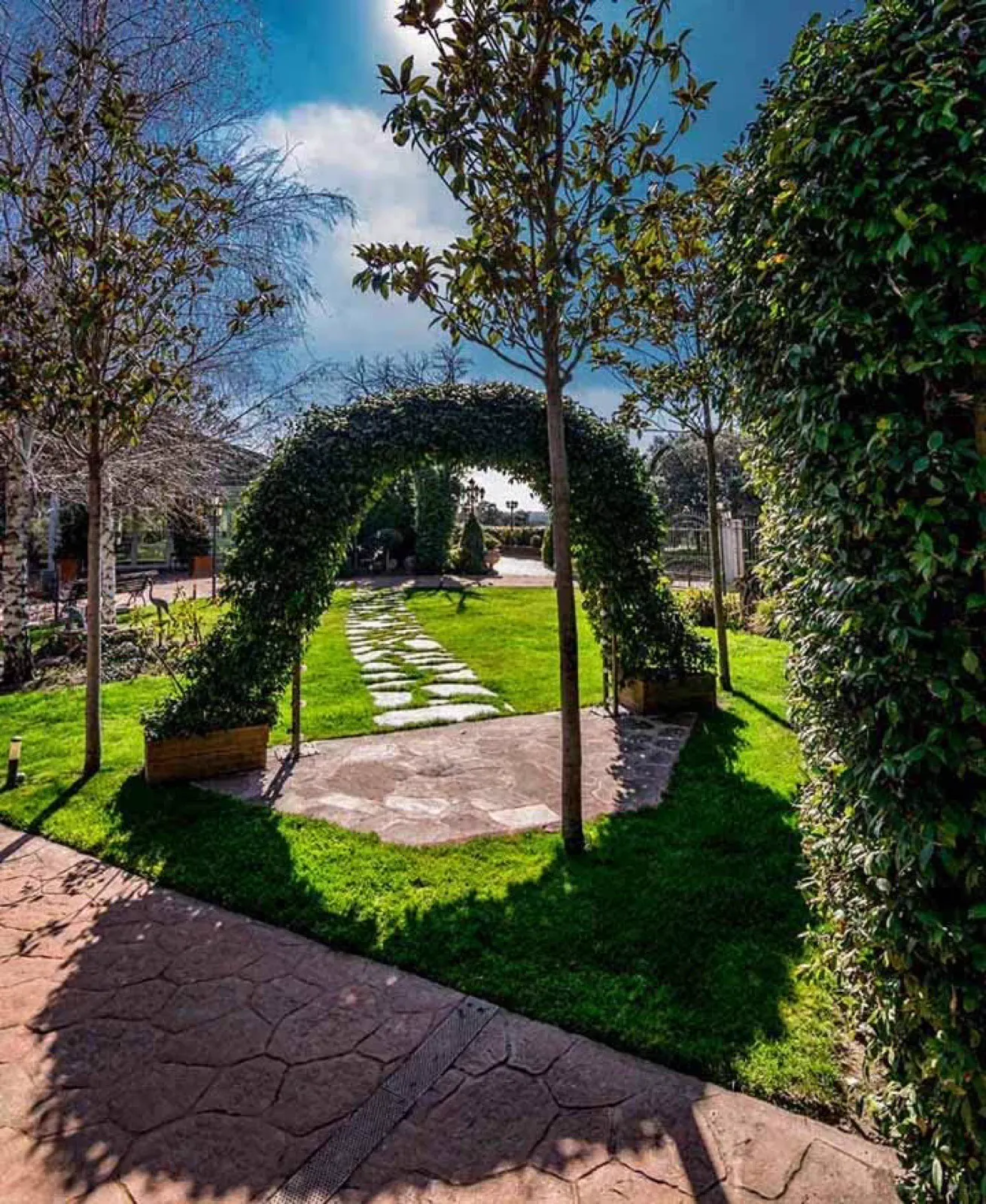 Arco vegetal y paseo de losas en el jardín